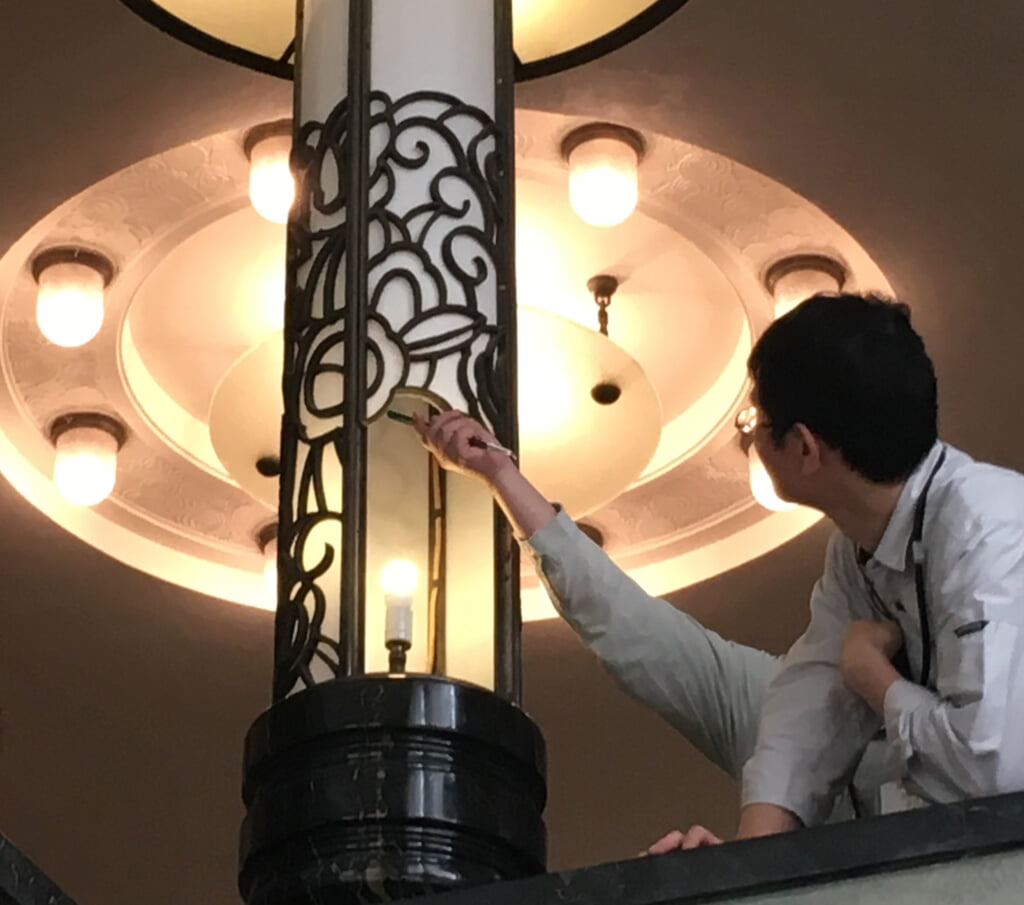 専門家が照明の電球を取り換える様子